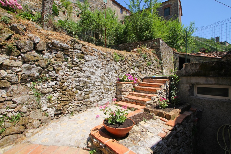 Zrenovovaný velký kamenný dům ve středověké obci v Garfagnaně